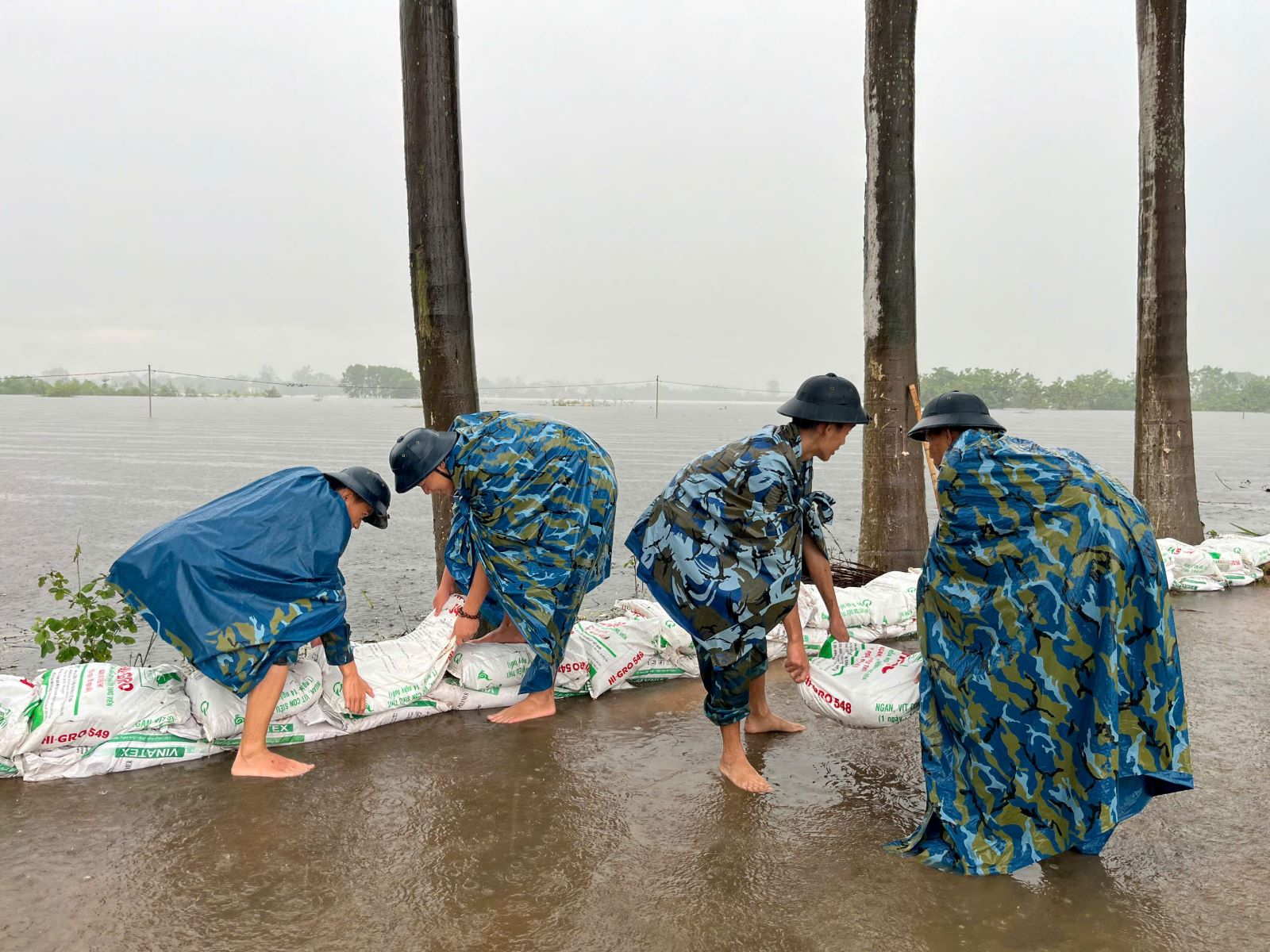 Huy động bộ đội cùng người dân đắp đê ngăn lũ ở huyện Sóc Sơn